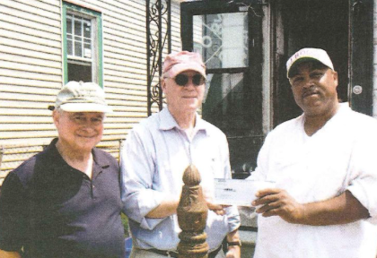 National Trust officials Peter Brink and Richard Moe present a check to homeowner David McGraw as part of the HOME AGAIN! program.