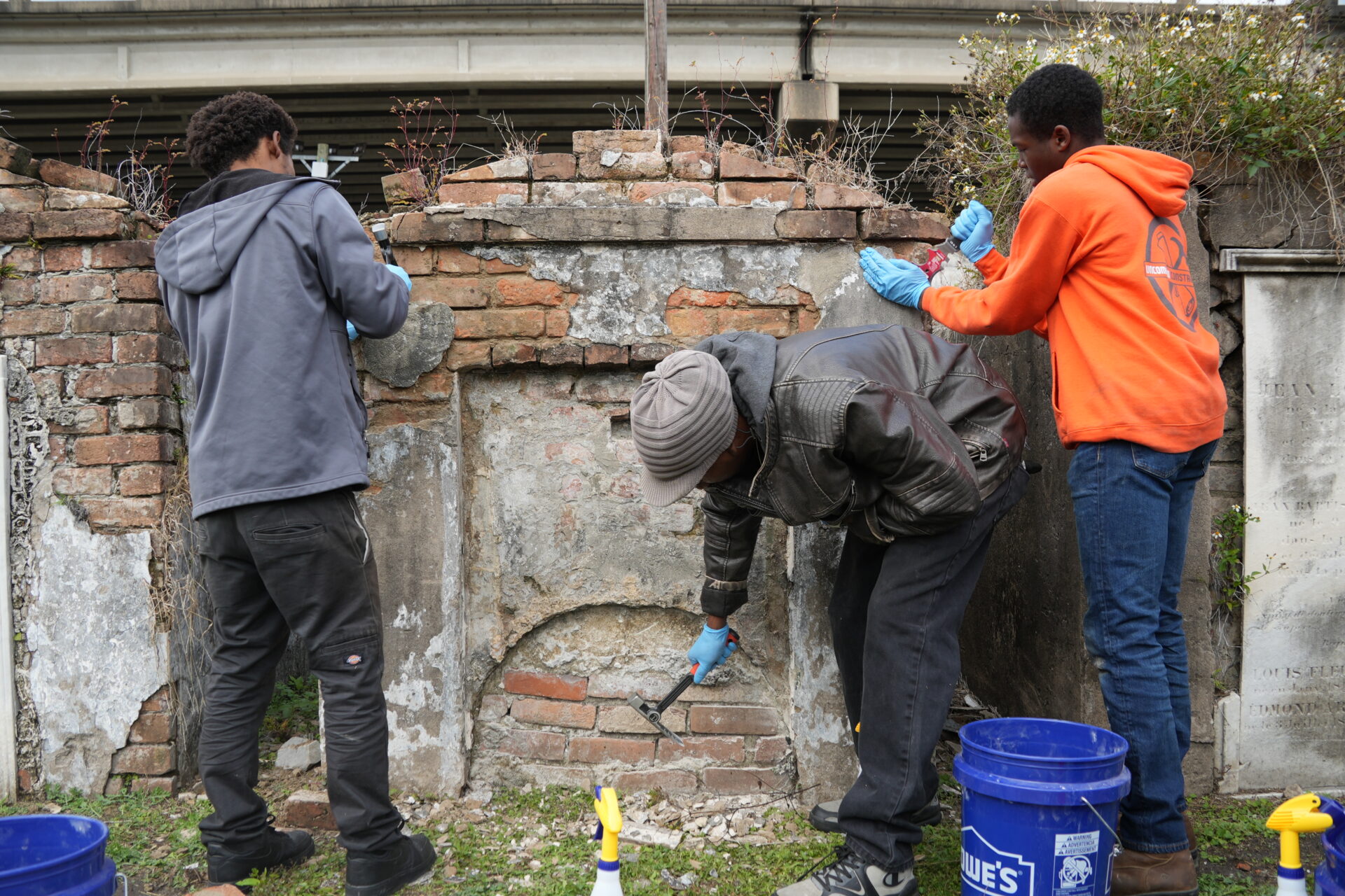 Participants in the Bridge to Crafts Careers program work on a tomb in St. Louis Cemetery No. 2.