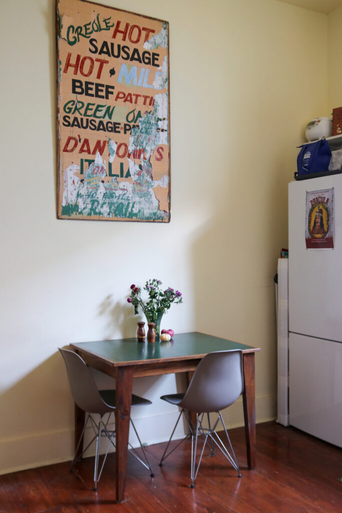 Small kitchen table sits under local New Orleans art.