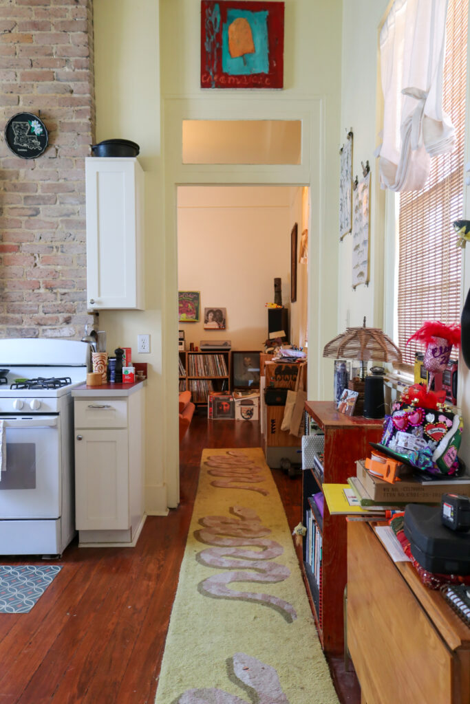 Looking down the hallway of a new Orleans shotgun home from the kitchen into the living room.