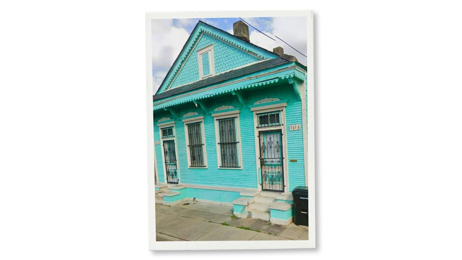 A turquoise New Orleans shotgun house with ornate gingerbread trim, barred windows, and a decorative front door.