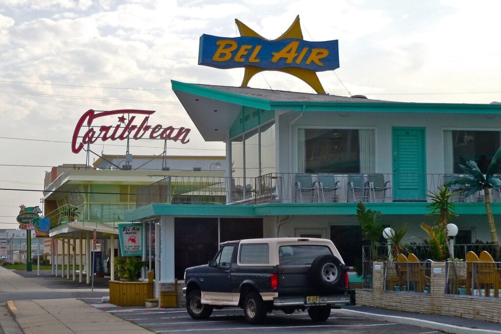 Bel Air motel with colorful mid-century modern architecture, a rooftop “Bel Air” sign and vintage “Caribbean” signage.