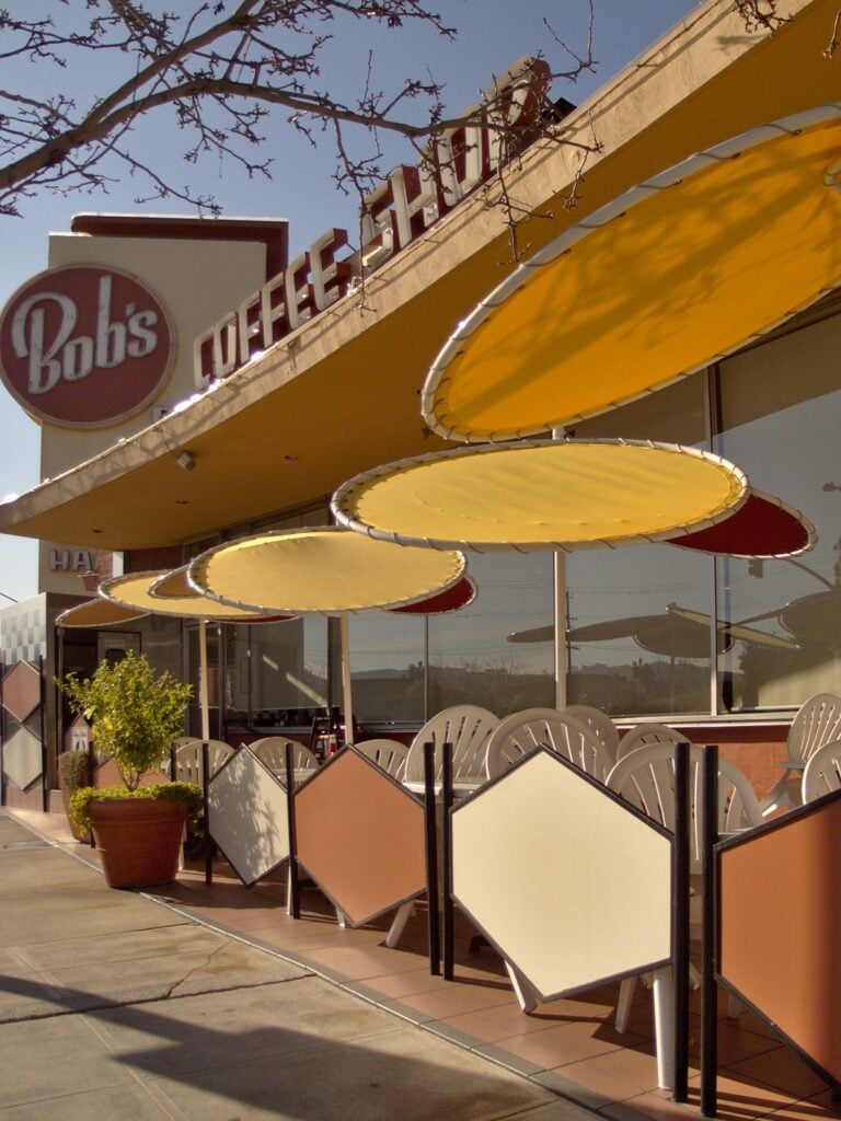 Bob’s Big Boy restaurant with a vintage rooftop sign and large yellow patio umbrellas over outdoor seating.