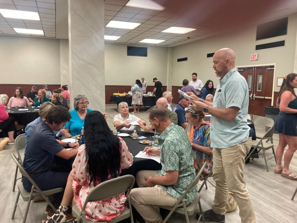 Community members participate in a visioning town hall in Thibodaux, Louisiana, working together at tables while a facilitator leads the discussion.