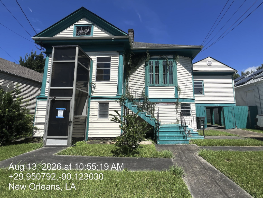 1830 Fern Street, a historic wood-frame house with white siding and distinctive turquoise trim, including a screened front entrance, decorative window surrounds, and an exterior staircase leading to the raised main floor.