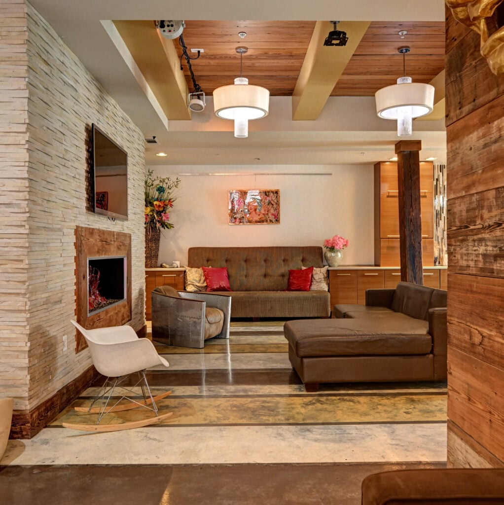Lounge area at St. Joe Lofts with stone fireplace, wood accents and mid-century furnishings