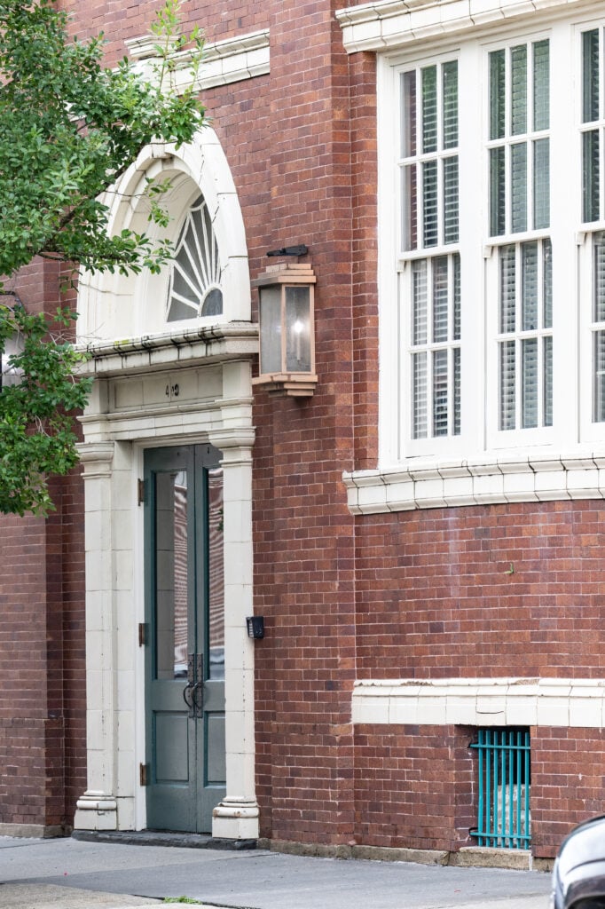 Exterior detail of St. Joe Lofts showing a brick facade, white-trimmed windows and entrance