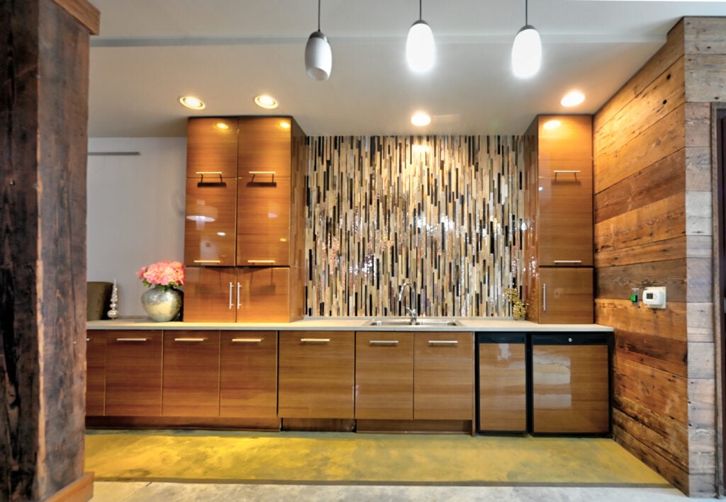 Kitchen at St. Joe Lofts with wood cabinetry, reclaimed wood walls and mosaic backsplash
