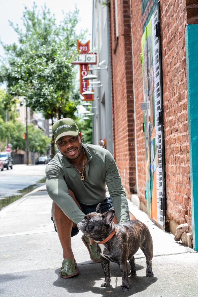Dustin Burks crouching beside his dog outside St. Joe Lofts
