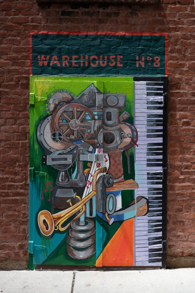 Colorful “Warehouse No. 8” mural featuring industrial machinery and musical instruments