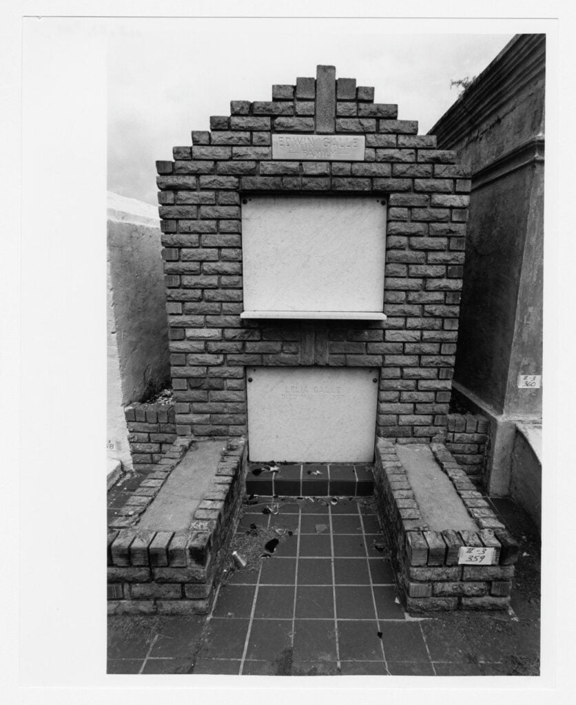 Black-and-white photograph of the Edwin Galle family tomb, a brick tomb with marble inscription panels and a tiled burial area at its base.