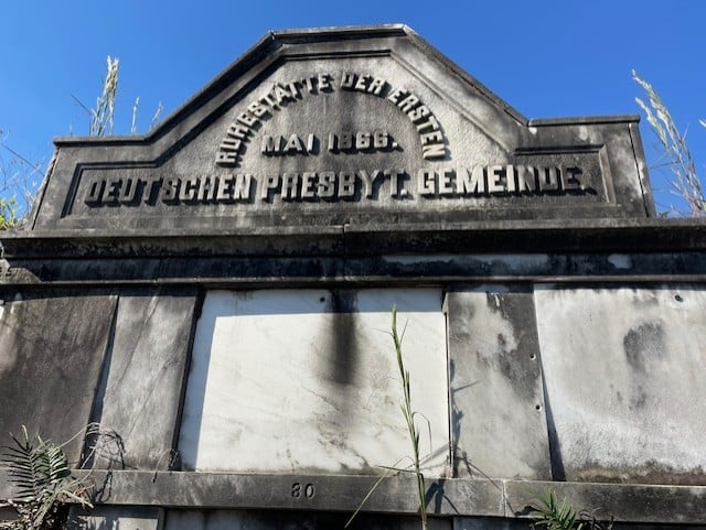 Close-up of the German Presbyterian tomb’s pediment in Lafayette Cemetery No. 1, featuring the inscription “Deutschen Presbyt. Gemeinde” and “Mai 1866” above weathered marble burial panels.
